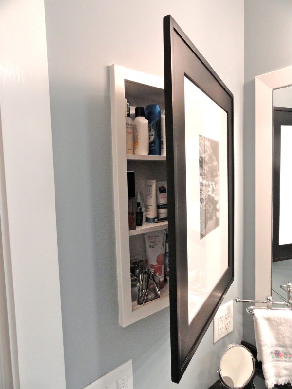 camouflage the door to a recessed wall cabinet between studs with a framed photo