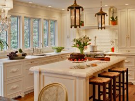 classic french country-inspired kitchen featuring benjamin moore linen white cabinets with white, honed calcutta marble countertops