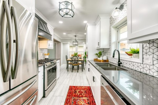 go for white tile kitchen flooring in this eat-in kitchen with a mosaic backsplash