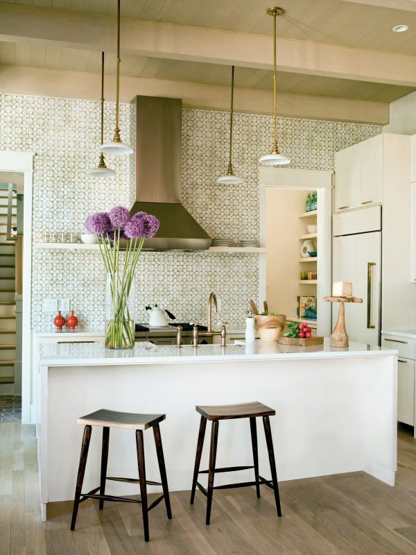 the beige mosaic backsplash perfectly adorns the kitchen using white cabinets with white countertops