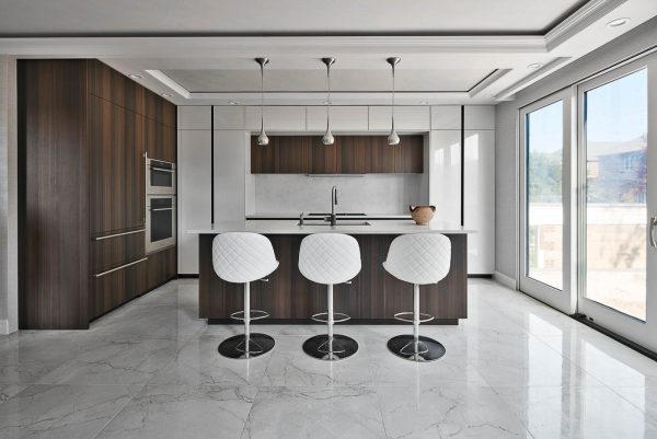 this beach style kitchen uses white tile floor and lacquered cabinetry for a sophisticated ambiance