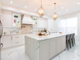 this glamorous white tile kitchen floor pairs antique pendant lights with marbled surfaces