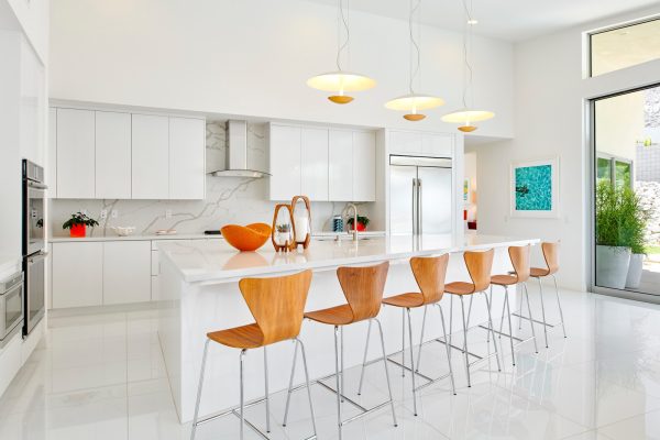 use wooden bar stools to create a nice contrast against the white tile kitchen floor and cabinetry