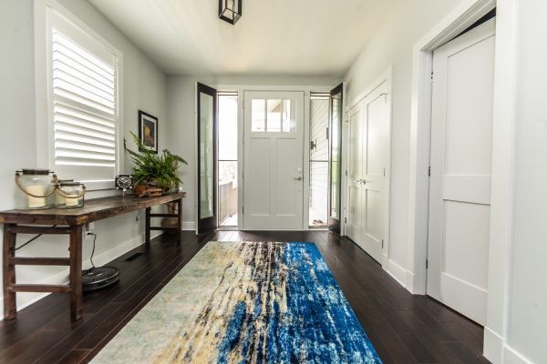 a multi-colored rug livens up this craftsman entryway with a white front door
