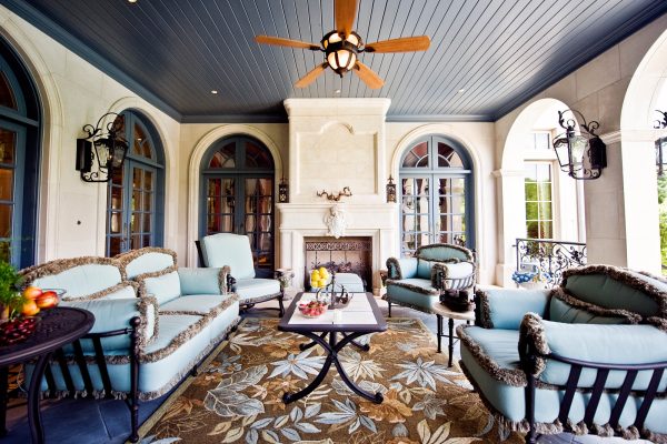 complete your semi-outdoor porch using antique french doors with transom and matching sofas