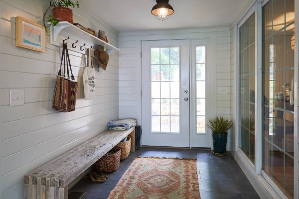 create warmth and coziness with grey porcelain tile floor that contrasts the white front door