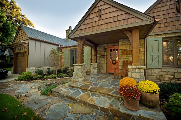 embrace the rustic allure with a stone wall exterior and a striking orange front door