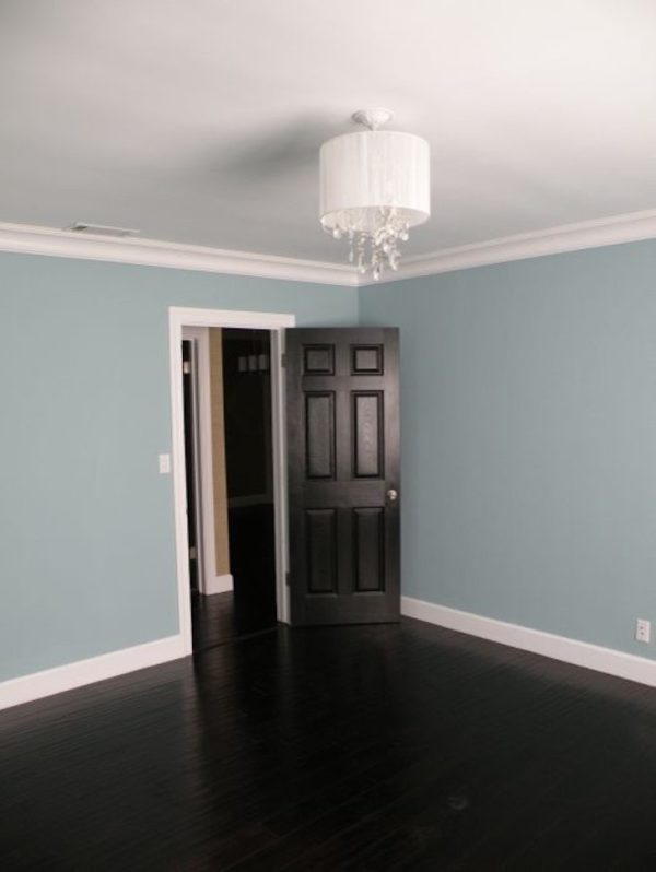 this black door and white trim complement the light blue walls for a classic interior feel