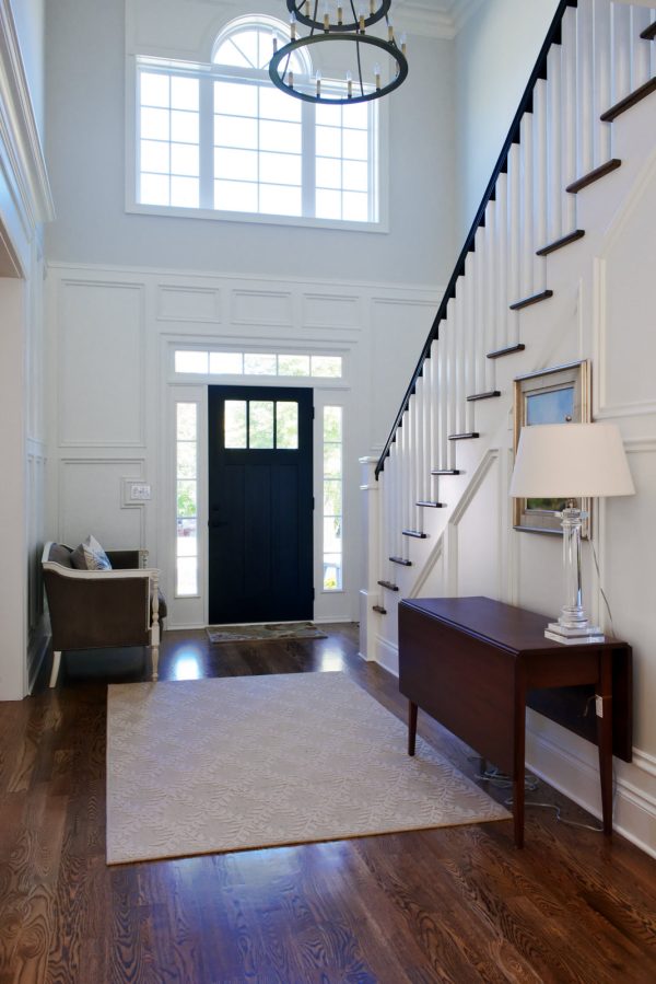 this bright, traditional foyer features ebony black doors and benjamin moore white dove trim