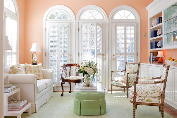 this stunning family room combines vibrant colors with white shutters for arched windows