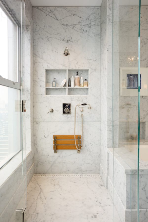 this urban and lavish shower features a four-part built-in shelf and fold-down bench