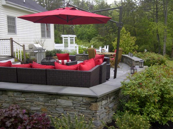 use a bright red upholstery idea that pops against bluestone retaining wall cap and colonial stone