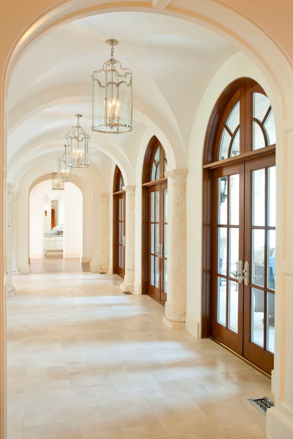 use brown french doors with a transom under a groin vaulted ceiling for a timeless appeal in the hallway