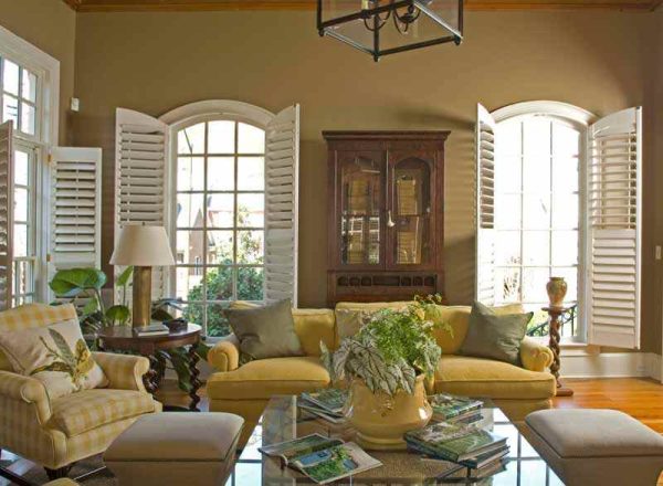 white shutters for the arched windows in a cozy living room with earthy tones