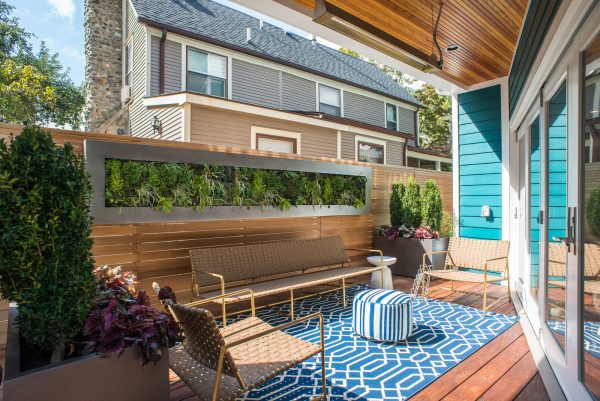 a geometric rug and pouf on a wood deck can elevate your small urban backyard with no grass