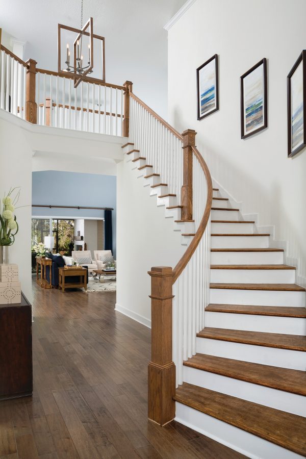 consider hanging photos and artwork along with an indoor vertical curved wood stair railing design