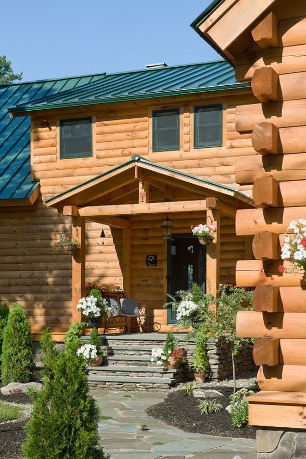 don’t skimp on flowers and greeneries to brighten a log cabin with green front doors
