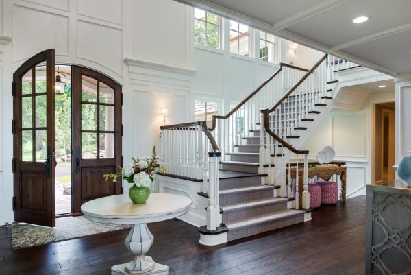 evoke beach vibes with this indoor wood stair railing with turned baluster design and arched double doors