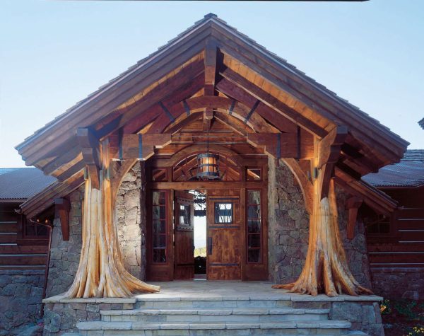 incorporate tree trunk columns that add drama to your log cabin’s double front doors