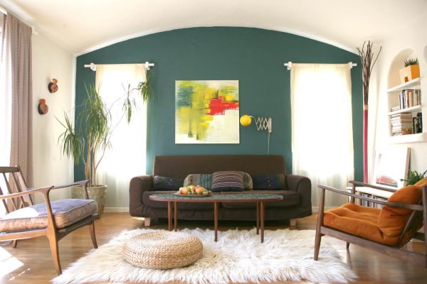 place a dramatic wool rug and vintage sconce to enhance the playfulness of a teal accent wall in the living room