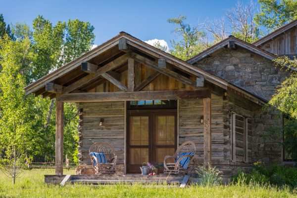 place rocking chairs on the patio for a humble log cabin with double front doors