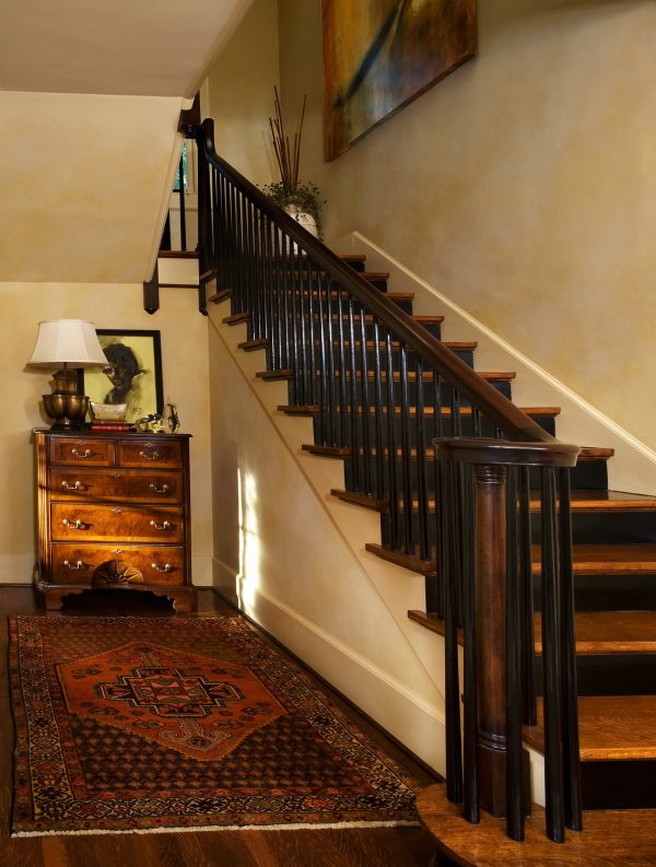 revive the timeless tudor style in this indoor dark walnut l-shaped wood stair railing design