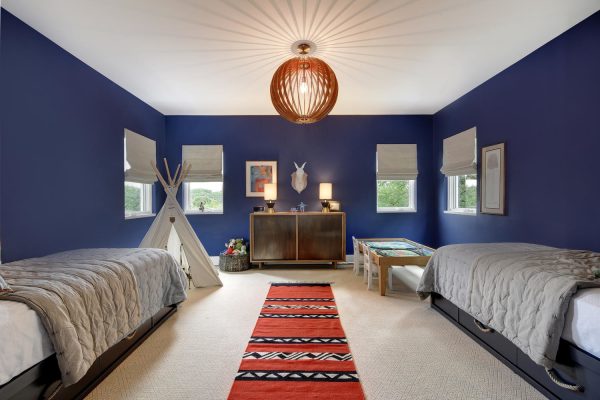 this beige carpet and dark blue wall color combination make for a modern but comfy kids’ room