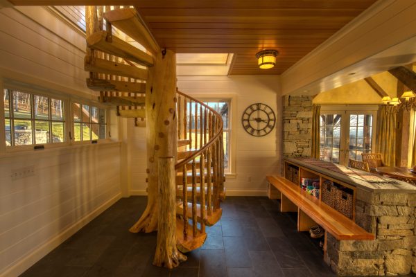 this spiraled indoor vertical wood stair railing incorporates a 25-feet tree for the ultimate rustic design