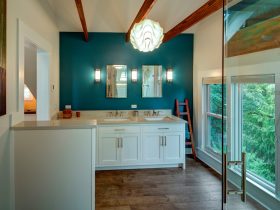 this teal accent wall uses benjamin moore’s venezuelan sea #2054-30 and wood ceiling beams for a cozy bathroom