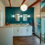 this teal accent wall uses benjamin moore’s venezuelan sea #2054-30 and wood ceiling beams for a cozy bathroom