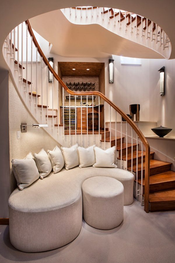 use a custom-designed sofa to embellish your curved indoor wood stair with a vertical railing design