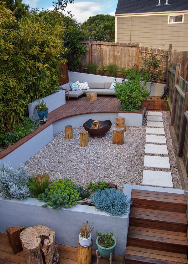 use pami pebbles, wood deck, and a fire pit in a small backyard with no grass for the ultimate modern comfort
