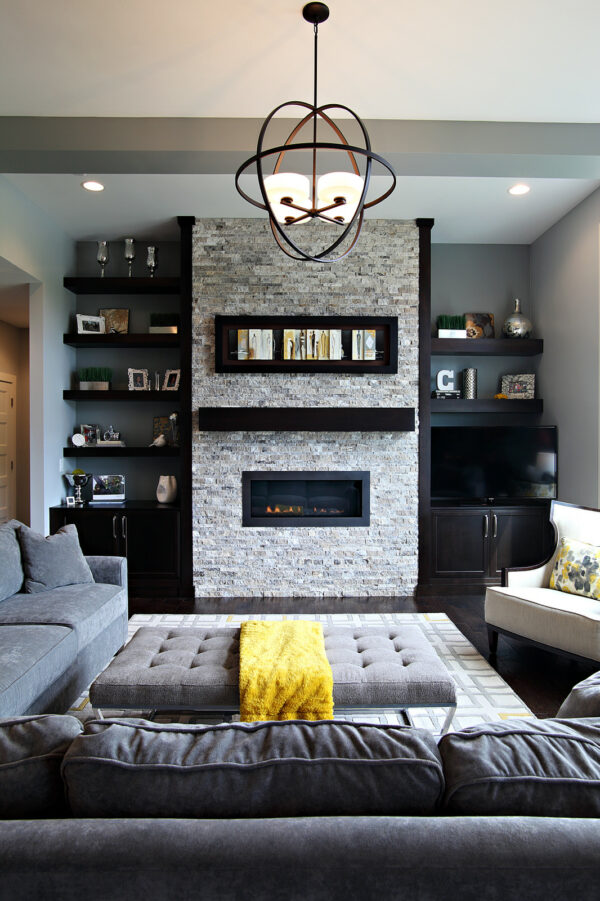dark gray accent wall enhances black floating shelves next to fireplace to create a modern living room with ample storage