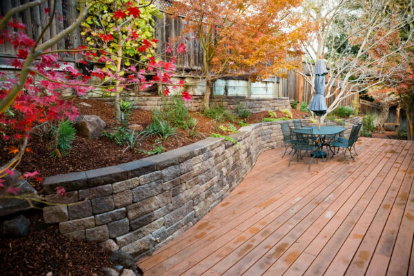 embrace rustic landscaping with a rugged fence on allan block’s europa retaining wall