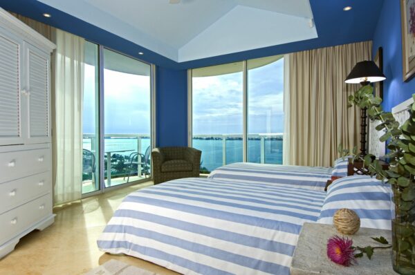 feature striped bedding and benjamin moore's evening blue with massive windows for a nature-centered royal blue bedroom