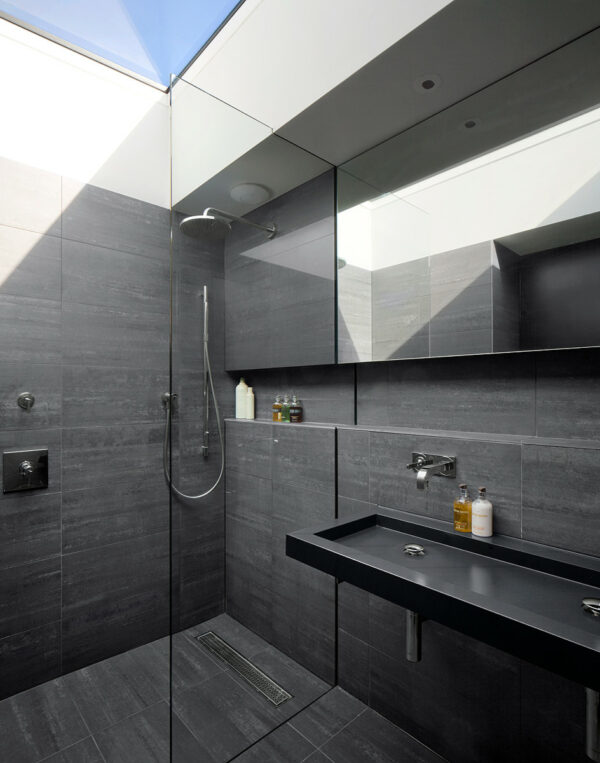 install a skylight and large mirrors in a dark grey bathroom for a bright and spacious effect