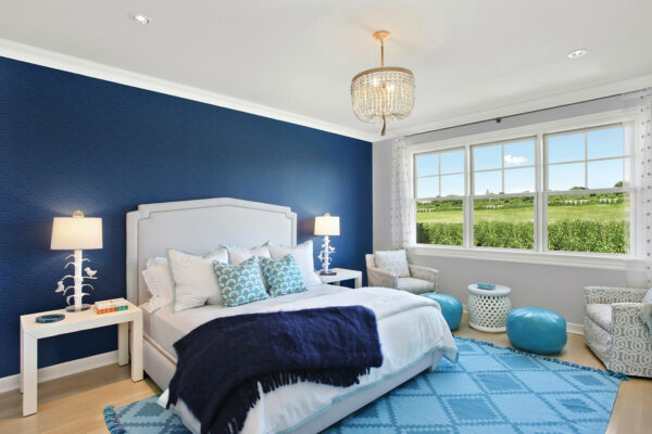 installing wallpaper as an accent wall for a royal blue bedroom with bright wood flooring can evoke a calming beachside vibe