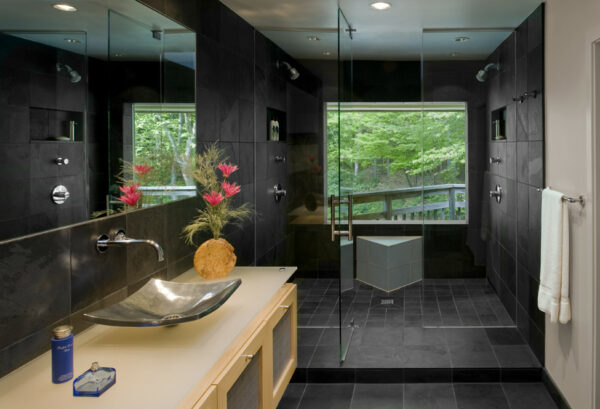 invoke calming japanese vibes in a dark grey bathroom with wood cabinets and an oversized window