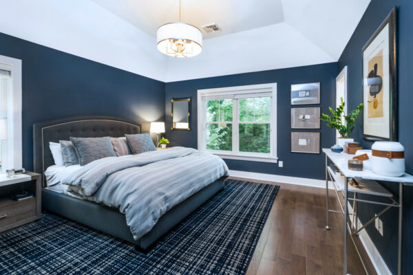 make a royal blue bedroom feel more alive with dark wood flooring, art pieces, and fresh greeneries