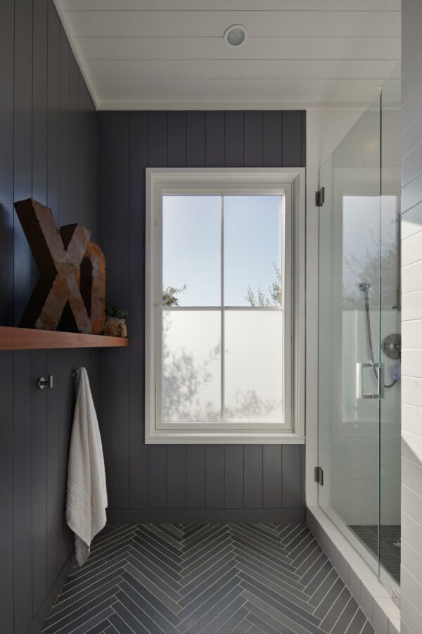 pair dark grey limestone tiles in a bathroom with white accents and thrifted decor for a modern-inspired farmhouse look