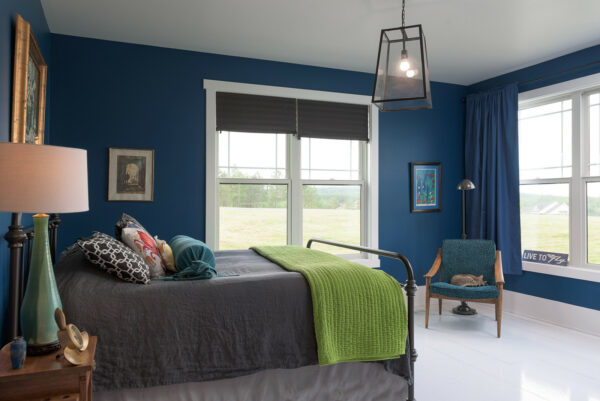 this dark, farmhouse styled royal blue bedroom looks striking with various exposed materials and vintage thrifts