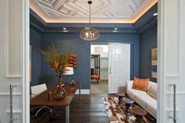 this navy blue office features ici-glidden mystery sound and a dramatic light fixture for a contemporary space