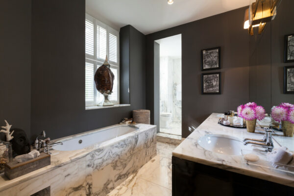 use elegant marble surfaces with bespoke dark grey color to evoke a lavish, contemporary bathroom
