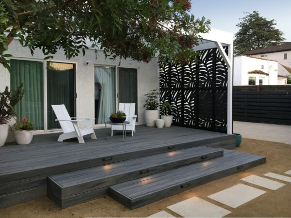 black trex deck and white accents can turn a small backyard into a charming modern oasis