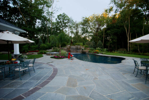 build a freeform pool to create an outdoor oasis amidst the irregular bluestone patio and luscious plantings