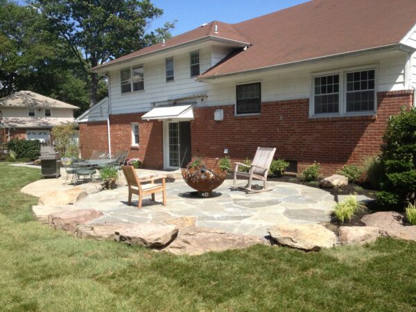 build a timeless patio with irregular bluestone and an industrial steel fire pit for a homey and comfortable atmosphere