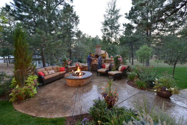 create a charming and cozy patio using stamped concrete patio with a fire pit and colorful flowers