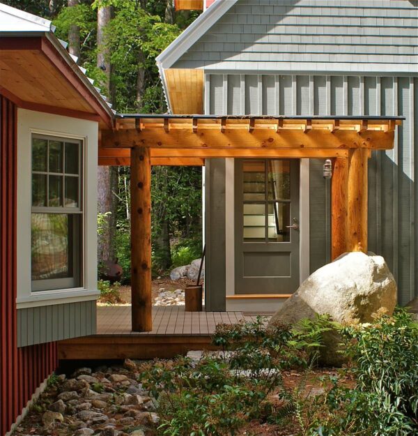 this grey and red exterior feature a rustic wooden front door pergola for a charming appeal