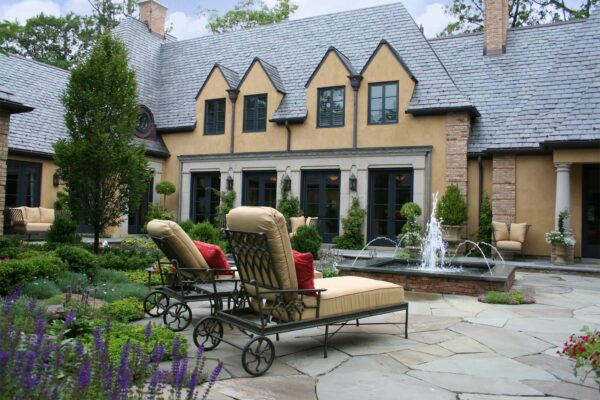 this serene patio features irregular bluestone flooring with an attractive water feature and perennial borders