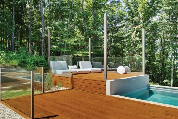 try an elegant vibe in your small backyard by combining a wood deck with metal poles and glass panel railings
